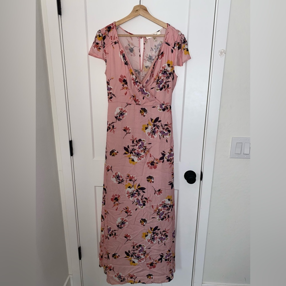 A soft, pink, floral and flowy dress designed with a V cut and sinched waist